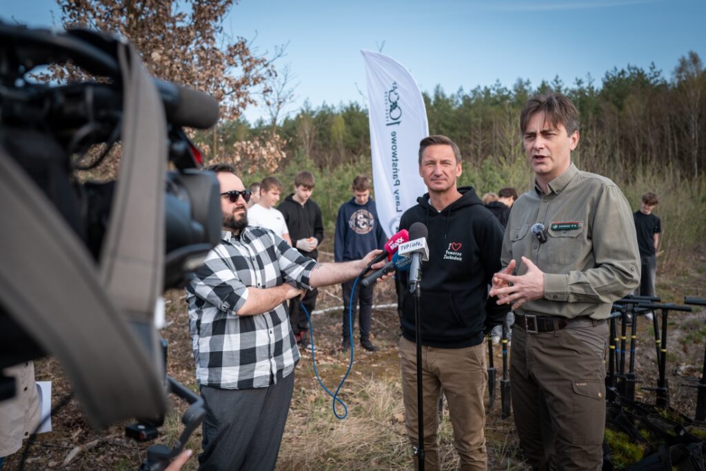 Marszałek Województwa Zachodniopomorskiego Olgierd Geblewicz, zastępca dyrektora ds. gospodarki leśnej Regionalnej Dyrekcji Lasów Państwowych w Szczecinie Maciej Szabla i młodzież podczas sadzenia lasu 15 kwietnia 2025 r.