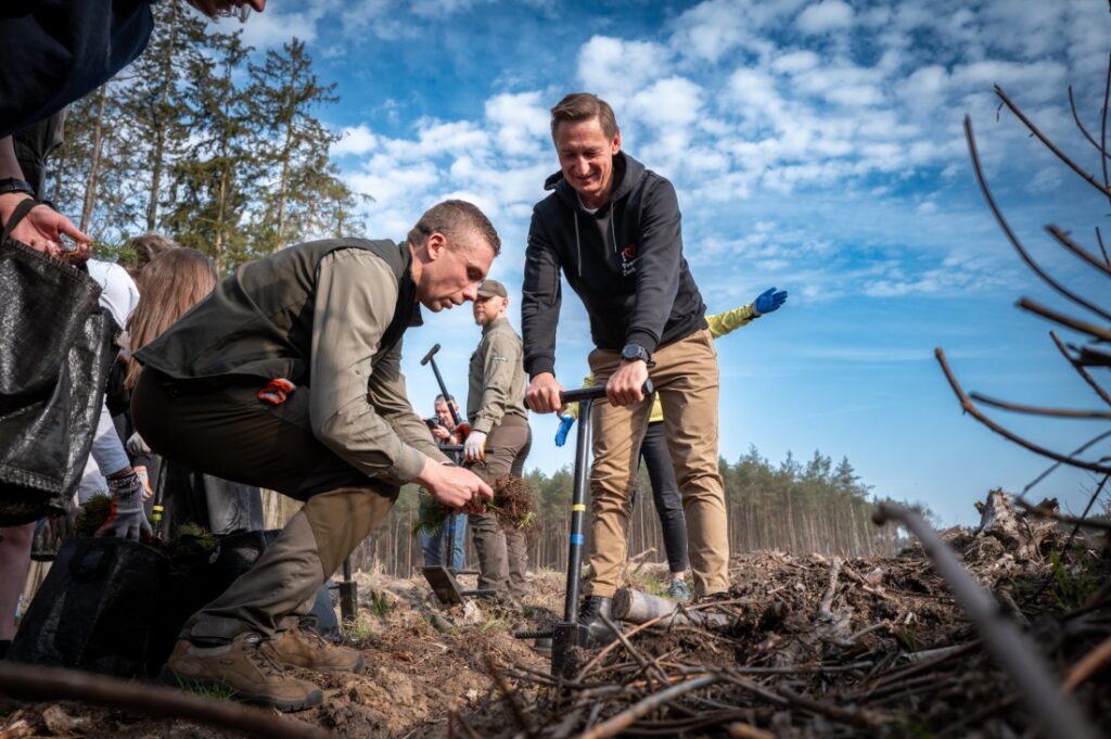 Marszałek Województwa Zachodniopomorskiego Olgierd Geblewicz, zastępca dyrektora ds. gospodarki leśnej Regionalnej Dyrekcji Lasów Państwowych w Szczecinie Maciej Szabla i młodzież podczas sadzenia lasu 15 kwietnia 2025 r.