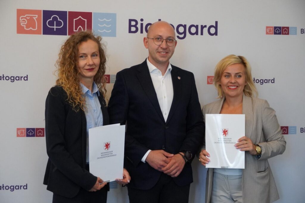 Wicemarszałek Województwa Zachodniopomorskiego Jakub Kowalik (w środku) podpisuje umowy o dofinansowanie dla miasta Białogard. 25 czerwca 2025 r.