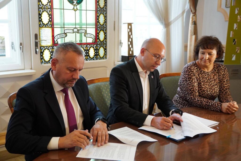 Wicemarszałek Województwa Zachodniopomorskiego Jakub Kowalik (w środku) podpisuje umowy o dofinansowanie dla gminy Karlino. 25 czerwca 2025 r.