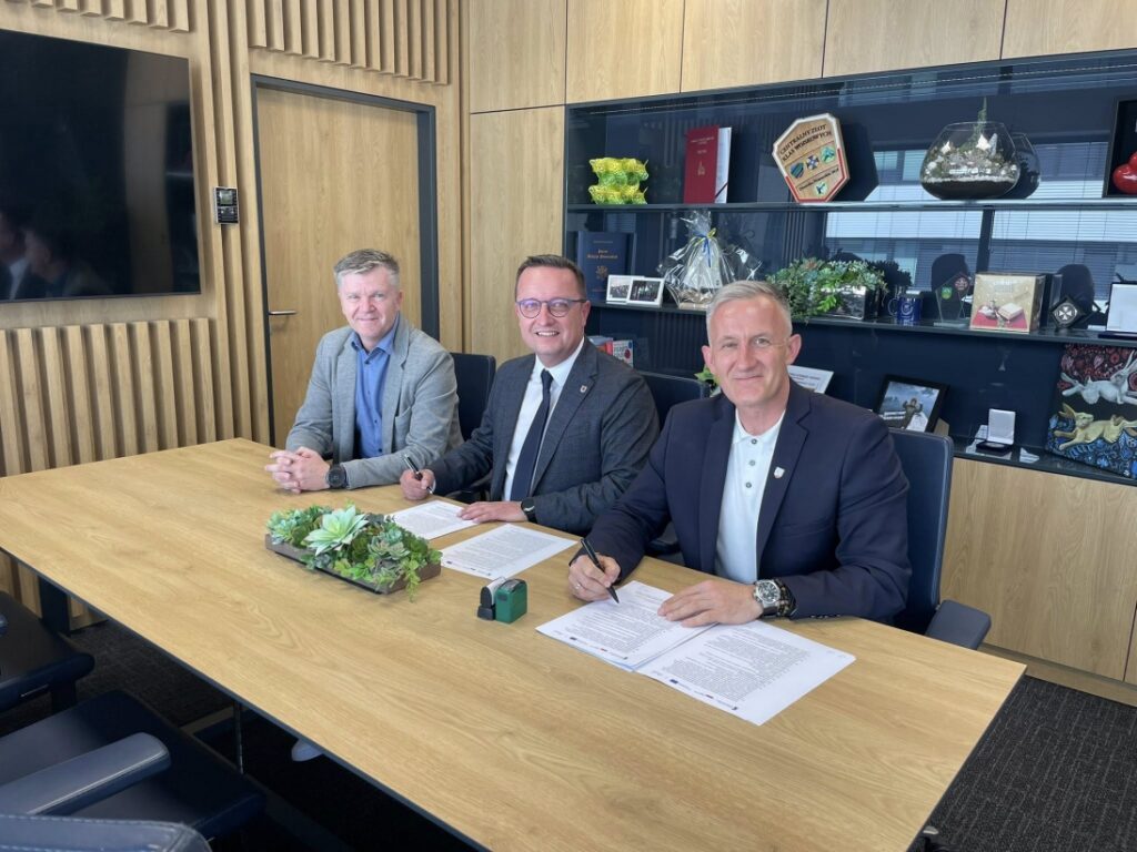 Członek Zarządu Województwa Zachodniopomorskiego Bogdan Jaroszewicz, burmistrz Nowogardu Michał Wiatr, radny województwa Damian Simiński podczas podpisywania umowy na realizację projektu „Gmina z Klimatem”, Nowogard, 3 czerwca 2025 r.